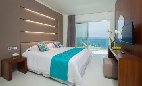 a hotel room with a bed and a television at King Evelthon Beach Hotel & Resort in Paphos City