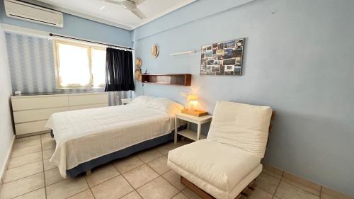 a small bedroom with a bed and a chair at El Trampolí By El Conserje in Denia