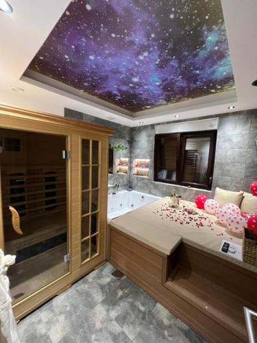 a bathroom with a bath tub and a star ceiling at You & Me spa apartment in Zlatibor