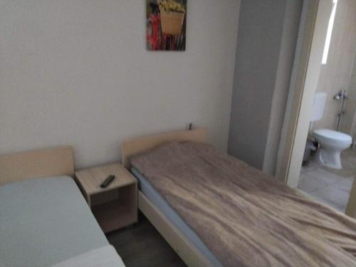 a small room with a bed and a toilet at Hostel Bela in Ohrid