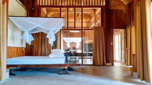 a bedroom with a bed with a canopy at Quỳnh Viên Resort in Dương Luật