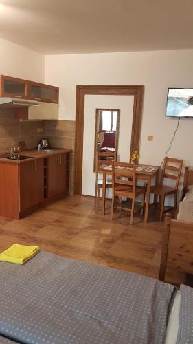 cocina y comedor con mesa y sillas en Apartmán 1, třílůžkový s přistýlkou s kuchyní a koupelnou en Frenštát pod Radhoštěm