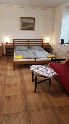 a bedroom with a bed and a table in it at Apartmán 1, třílůžkový s přistýlkou s kuchyní a koupelnou in Frenštát pod Radhoštěm