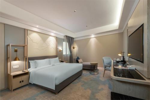 um quarto de hotel com uma cama e uma televisão em Aber Abha em Abha