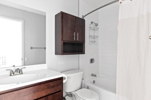 a bathroom with a toilet and a sink and a tub at Gold Coast 1BR w Deck Gym Lounge 1 block to L CHI-650 in Chicago