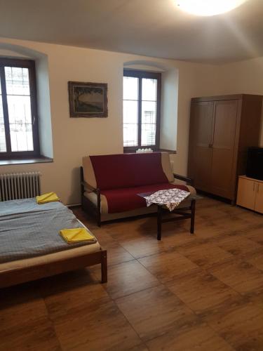 sala de estar con cama y sofá en Apartmán 1, třílůžkový s přistýlkou s kuchyní a koupelnou, en Frenštát pod Radhoštěm