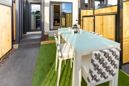 una mesa y sillas en un patio con césped en A Road Away from Hagley Park 2 bed 2 bath, en Christchurch