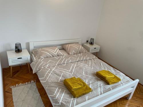 uma cama com duas almofadas amarelas num quarto em Apartment Tulip em Premantura