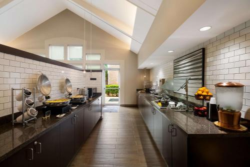 a large kitchen with black counters and a long hallway at Sonesta ES Suites Dallas Richardson in Richardson