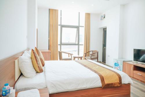 um quarto com uma cama grande e uma televisão em Sky Night Hotel Bắc Ninh em Bồ Sơn
