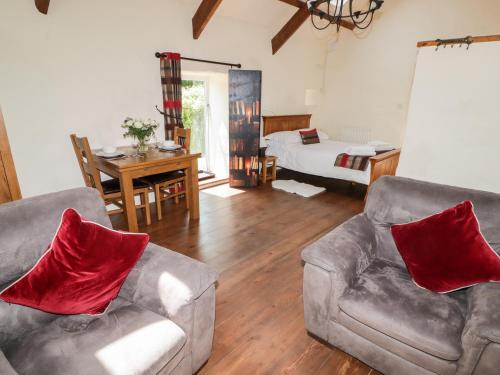 uma sala de estar com 2 sofás e um quarto em The Old Stable em Haverfordwest