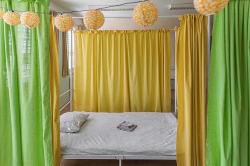 a bedroom with green and yellow curtains and a bed at TEJ HOSTEL in Ljubljana