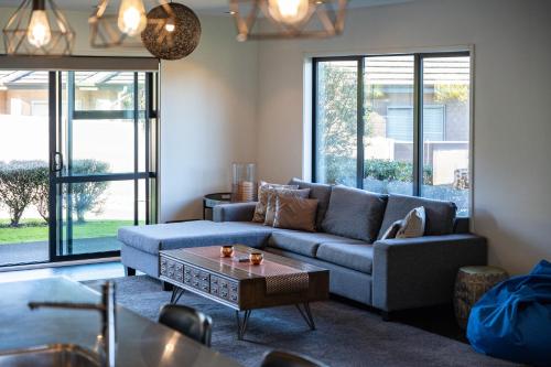 een woonkamer met een bank en een salontafel bij Riverside in Taupo