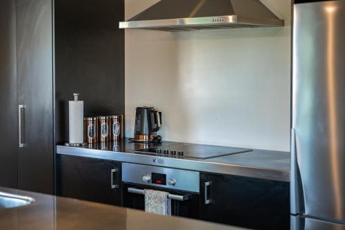 een keuken met een roestvrijstalen fornuis top oven bij Riverside in Taupo