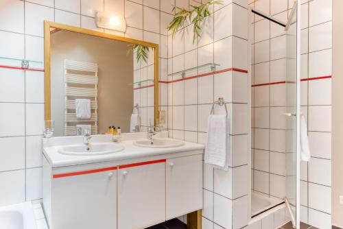 a bathroom with two sinks and a mirror at Gîte 2 Maison Caerdinael - Gîte de 9 personnes dans le centre de Durbuy in Durbuy