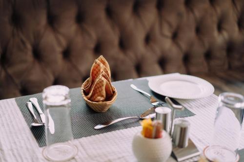 a table with a plate of food and a basket of bread at The Amariah Hotel & Apartments Mikocheni in Dar es Salaam