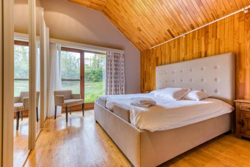 a bedroom with a large bed with a wooden ceiling at Gîte 2 Maison Caerdinael - Gîte de 9 personnes dans le centre de Durbuy in Durbuy