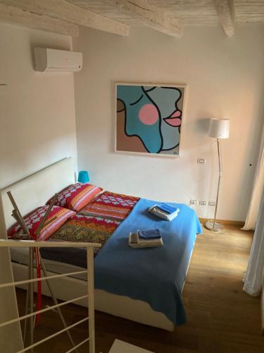 una camera da letto con un letto e un dipinto sul muro di Piccolo Palazzo a San Felice del Benaco