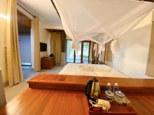 a bedroom with a large bed with a wooden floor at Quỳnh Viên Resort in Dương Luật