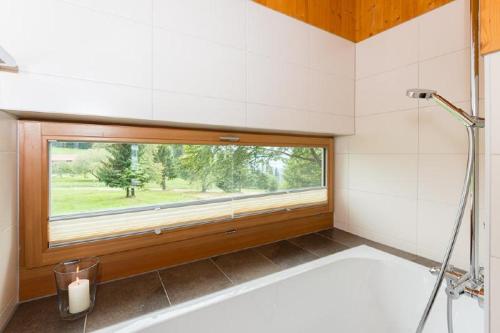 łazienka z wanną i oknem w obiekcie GutsAlm Harlachberg w mieście Bodenmais