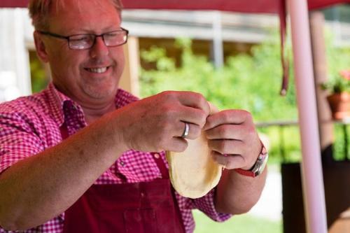a man holding a piece of bread in his hands at GutsAlm Harlachberg in Bodenmais