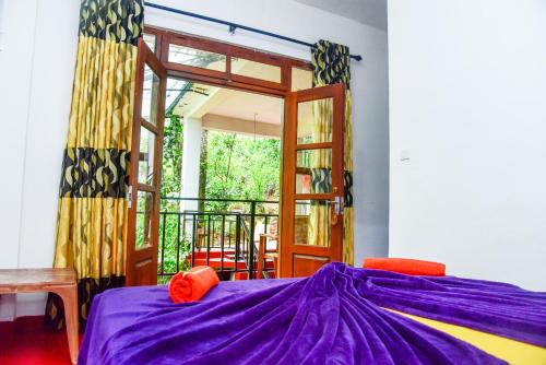 a bedroom with a purple bed and a balcony at MUM Jungle Inn in Ella