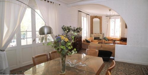 un salon avec un vase de fleurs sur une table dans l'établissement Maison Fontaine, à Espira-de-lʼAgly