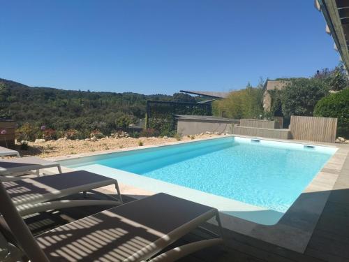 une piscine avec deux chaises et une piscine dans l'établissement La Bernardière du Ventoux 2, à Mollans-sur-Ouvèze
