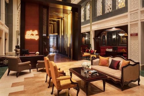 a lobby with a couch and chairs and a table at Jumeirah Zabeel Saray Dubai in Dubai