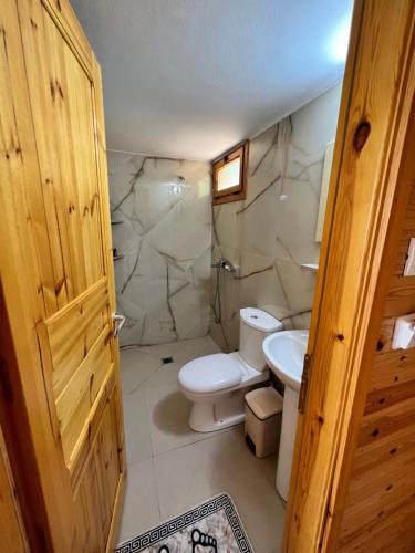 łazienka z toaletą i umywalką w obiekcie Nashos Bungalows w mieście (( Spile ))