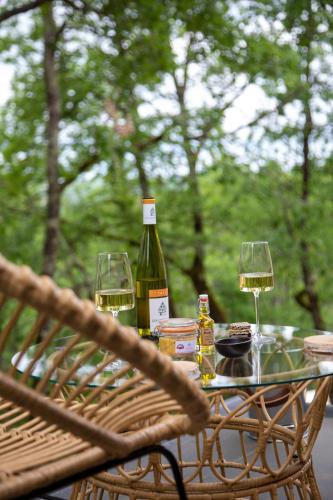 a table with two glasses of wine on it at La Perle de Domme in Sarlat-la-Canéda