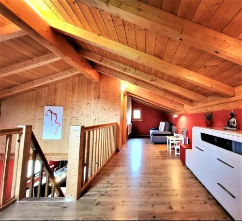 un soggiorno con soffitti in legno e una scala di Allgäuferienhaus Sandra a Lechbruck