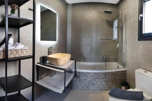 y baño con bañera, lavamanos y ducha. en Lamzi's Residence en La Canea