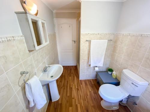 a bathroom with a toilet and a sink at Stay on Main, Family Apartment in Paarl