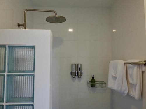 a bathroom with a shower with white tiles at Bougain Villas in Chiang Dao