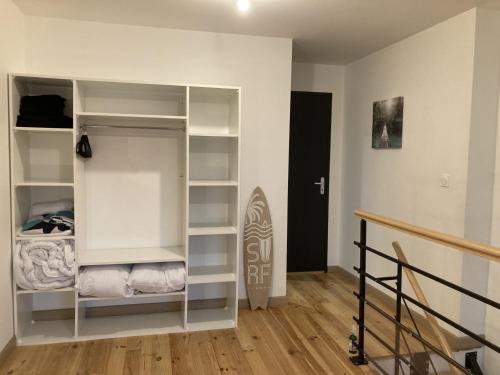 una habitación con estanterías blancas y una escalera en Appartement au cœur d'Espalion Le Perchoir du Lot, en Espalion
