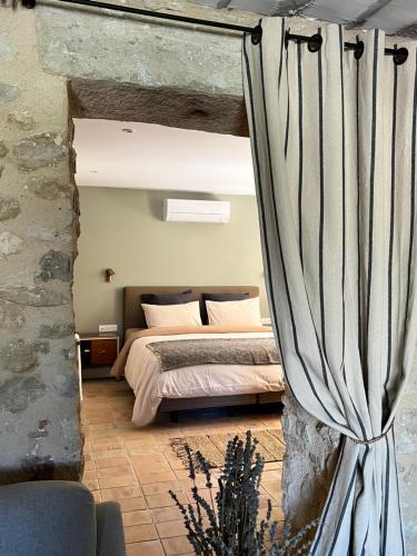 - une chambre avec un lit et un rideau dans l'établissement Mas Saint-Genies, à Venasque