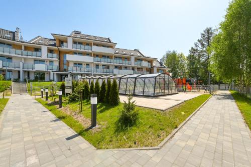 un edificio con jardín frente a un edificio en Flatbook Apartamenty - Sztutowo Baltic Garden, en Sztutowo