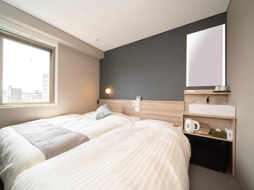Letto o letti in una camera di Super Hotel Premier Sendai Kokubuncho Tennenonsen