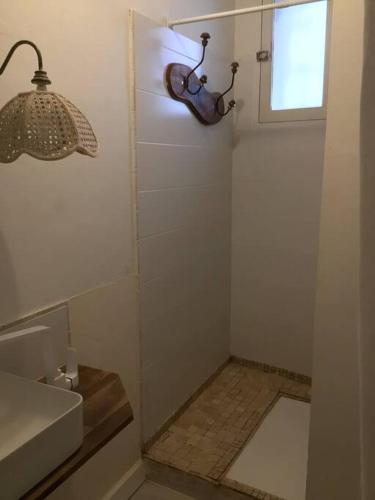 une petite salle de bain avec un lavabo et une fenêtre dans l'établissement Appartement au coeur du village pour deux personnes, à Lespignan
