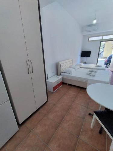 a room with a bed and a desk and a table at ARTEMISA APARTMENTS in Vlorë