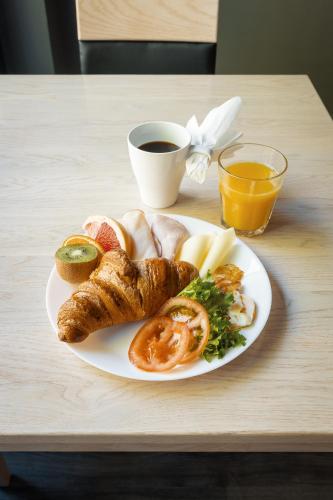 a plate of breakfast food with a cup of coffee at Hotelli Uninen Loviisa in Lovisa