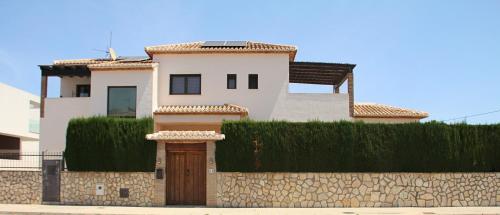 una grande casa bianca con un muro di pietra di Resort Villa Luny Gandia a Gandía