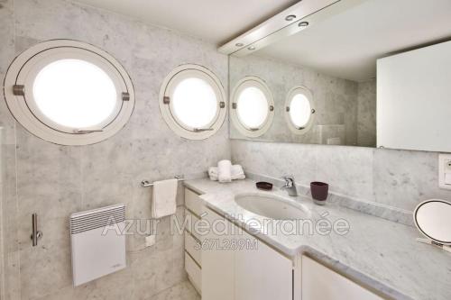 une salle de bain avec un lavabo et deux fenêtres dans l'établissement Villa Mariella, à Saint-Jean-Cap-Ferrat