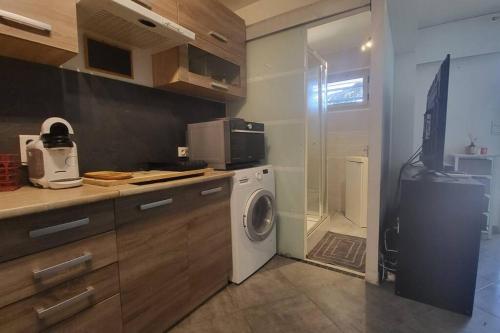 eine Küche mit einer Waschmaschine und einem Kühlschrank in der Unterkunft Cagnes/Mer Hippodrome - Terrasse 20m² proche mer in Cagnes-sur-Mer