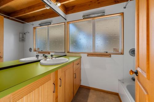 a bathroom with two sinks and two windows at Moore in Turangi in Turangi