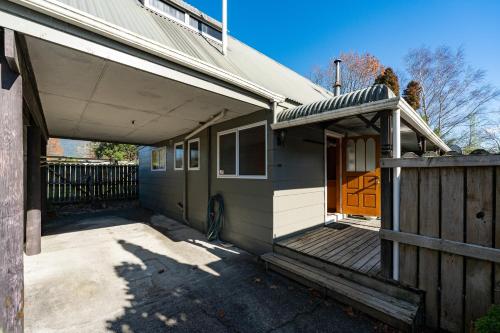 a house with a porch and a wooden fence at Moore in Turangi in Turangi