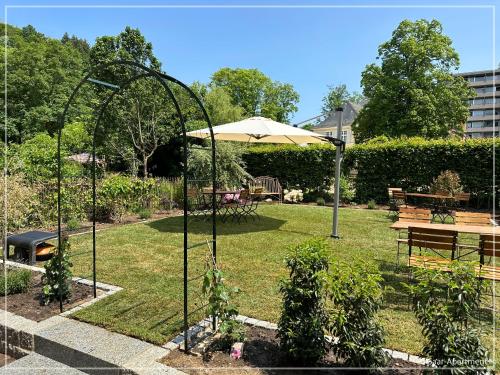 a garden with an umbrella and a table and bench at Saar-Apartments in Merzig