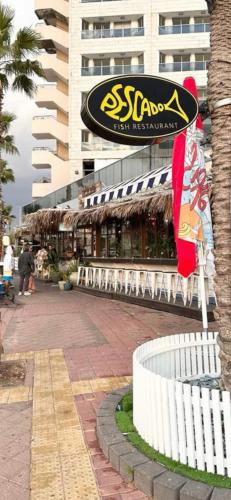 a restaurant with a sign on the side of a building at Sima Suite in Ashdod