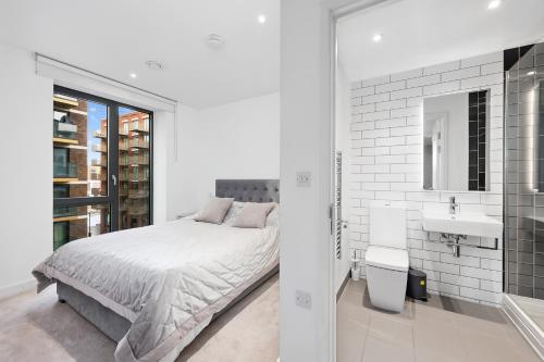 a white bedroom with a bed and a sink at Riverside View Apartments in London